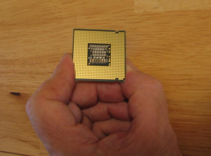 Carefully Pick Up The CPU - Don't Touch The Copper Colored Pads On The Bottom!